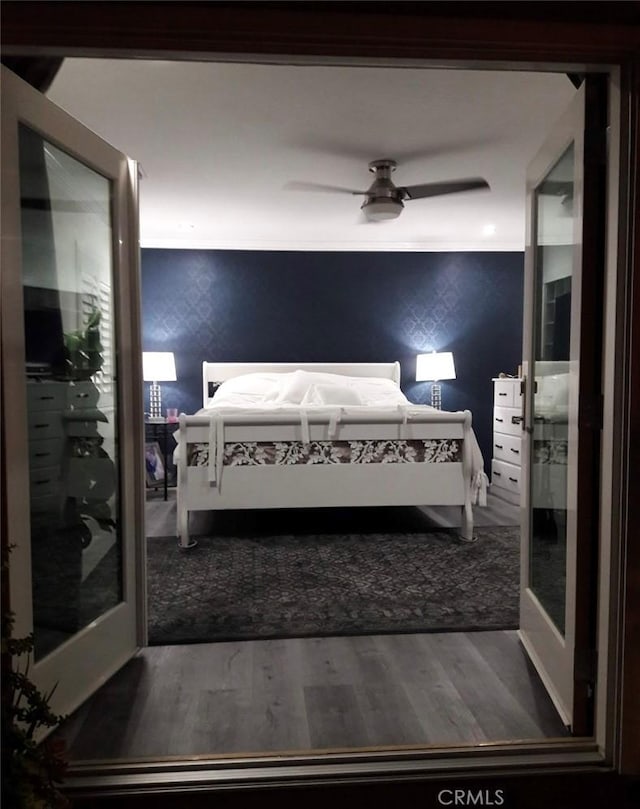 11022 Maple St, Whittier, CA 90601 - bedroom featuring wood finished floors, a ceiling fan, wallpapered walls, and an accent wall