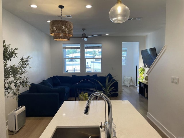 7641 University Ave Unit 105, La Mesa, CA 91942 - kitchen featuring a sink, wood finished floors, open floor plan, hanging light fixtures, and a ceiling fan