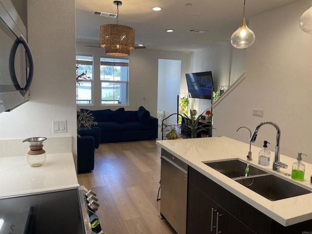 7641 University Ave Unit 105, La Mesa, CA 91942 - kitchen with a sink, dishwasher, open floor plan, dark cabinetry, and light wood finished floors