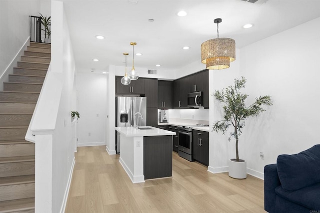 7641 University Ave Unit 105, La Mesa, CA 91942 - kitchen with stainless steel appliances, open floor plan, light wood-style flooring, light countertops, and decorative light fixtures