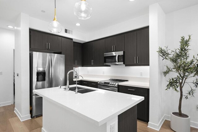 7641 University Ave Unit 105, La Mesa, CA 91942 - kitchen with stainless steel appliances, a sink, light countertops, light wood finished floors, and recessed lighting