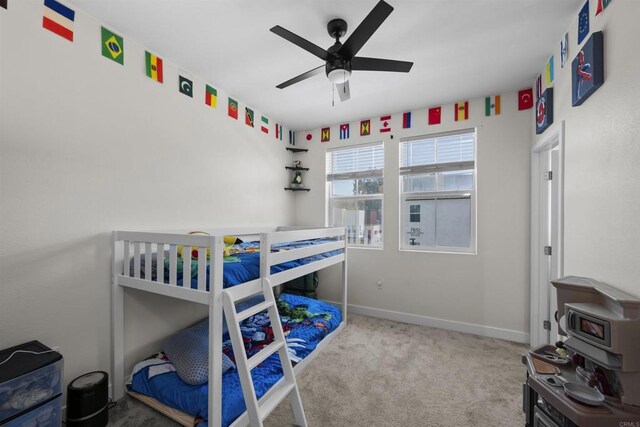 7641 University Ave Unit 105, La Mesa, CA 91942 - carpeted bedroom featuring baseboards, a wood stove, and a ceiling fan