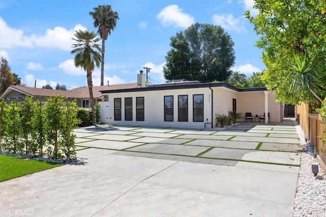 22452 Dolorosa St, Woodland Hills, CA 91367 - rear view of property with stucco siding, a patio, and a chimney