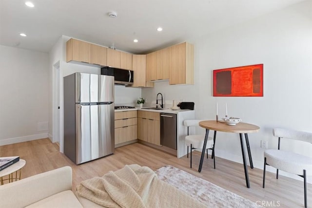 22452 Dolorosa St, Woodland Hills, CA 91367 - kitchen with appliances with stainless steel finishes, light brown cabinets, light wood finished floors, light countertops, and baseboards