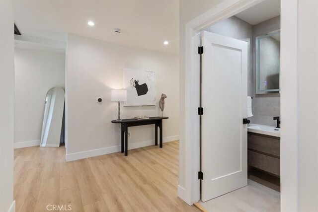 22452 Dolorosa St, Woodland Hills, CA 91367 - hallway with light wood-style flooring, baseboards, recessed lighting, and a sink
