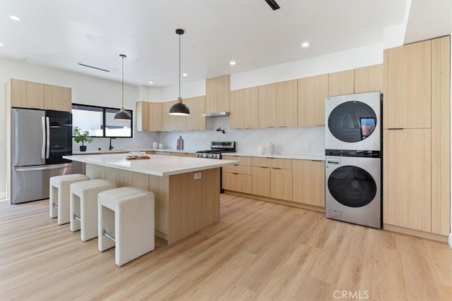 22452 Dolorosa St, Woodland Hills, CA 91367 - kitchen featuring appliances with stainless steel finishes, stacked washer / drying machine, light brown cabinets, modern cabinets, and light countertops
