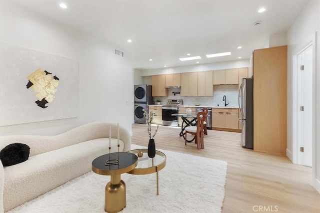 22452 Dolorosa St, Woodland Hills, CA 91367 - living room with stacked washer and clothes dryer, light wood-style flooring, recessed lighting, and baseboards