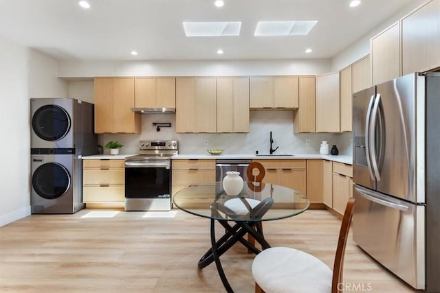 22452 Dolorosa St, Woodland Hills, CA 91367 - kitchen with stainless steel appliances, stacked washing machine and dryer, light brown cabinetry, and recessed lighting