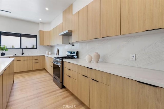 22452 Dolorosa St, Woodland Hills, CA 91367 - kitchen with stainless steel range with gas cooktop, light brown cabinets, modern cabinets, under cabinet range hood, and backsplash