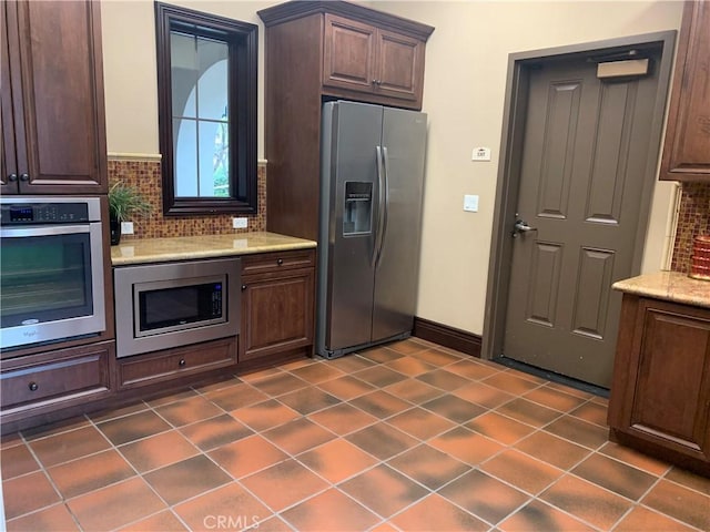3407 Paseo Dr, Brea, CA 92823 - kitchen featuring appliances with stainless steel finishes, tasteful backsplash, light stone counters, and dark brown cabinets