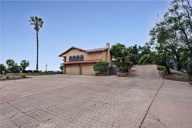 350 Roughrider Rd, La Verne, CA 91750 - view of front of house featuring a chimney, a tiled roof, a garage, decorative driveway, and stucco siding