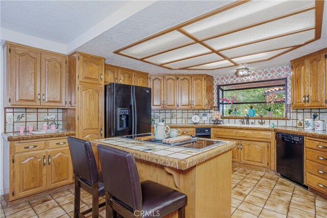 350 Roughrider Rd, La Verne, CA 91750 - kitchen with black appliances, a sink, light tile patterned floors, a center island, and tasteful backsplash