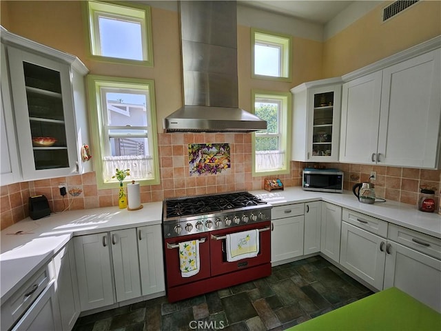 9740 La Canada Way, Shadow Hills, CA 91040 - kitchen featuring range with two ovens, stainless steel microwave, wall chimney range hood, stone finish floors, and plenty of natural light
