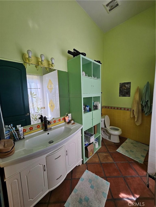 9740 La Canada Way, Shadow Hills, CA 91040 - bathroom with tile patterned floors, toilet, vanity, wainscoting, and tile walls