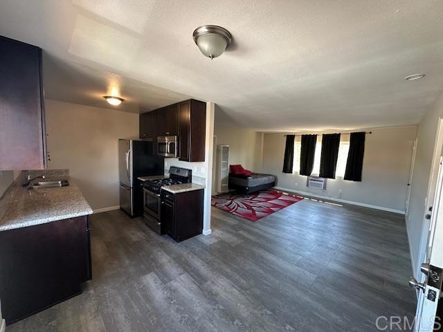 9731 Winter Gardens Blvd Unit 54, Lakeside, CA 92040 - kitchen featuring appliances with stainless steel finishes, open floor plan, a sink, dark wood-style flooring, and dark brown cabinets