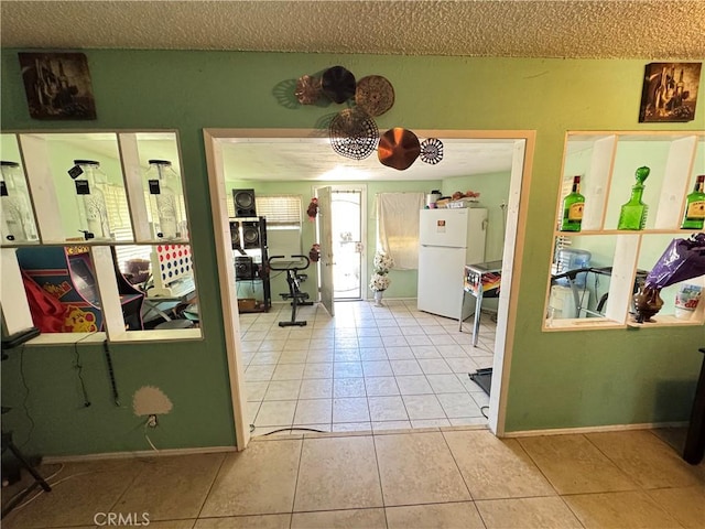 45529 Sancroft Ave, Lancaster, CA 93535 - interior space featuring freestanding refrigerator, tile patterned flooring, healthy amount of natural light, a textured ceiling, and baseboards
