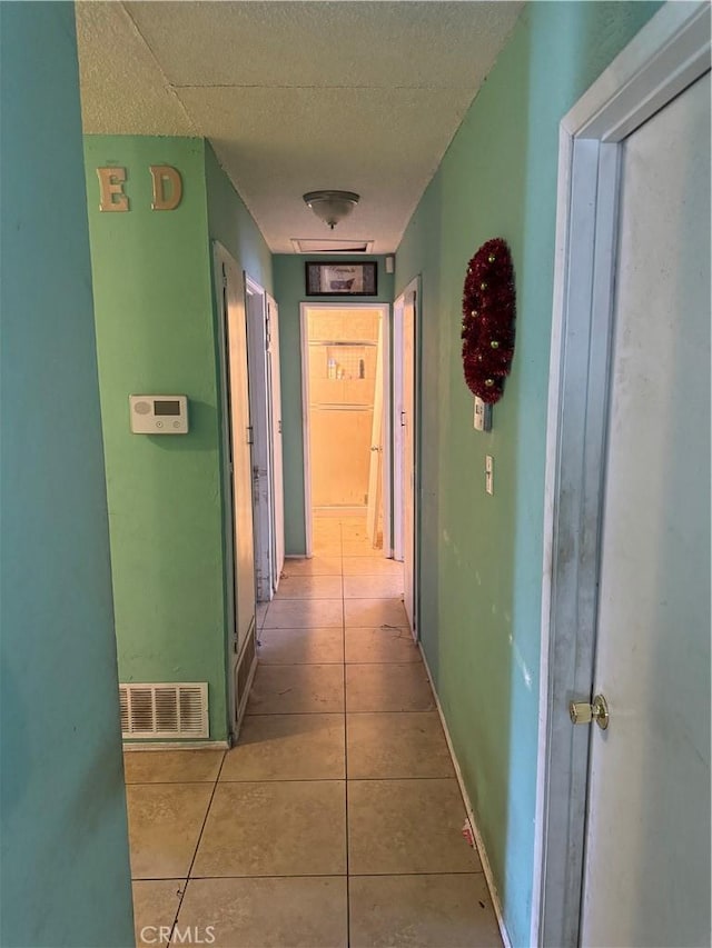 45529 Sancroft Ave, Lancaster, CA 93535 - hallway with tile patterned floors, a textured ceiling, and baseboards