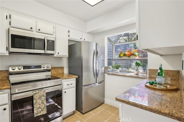 25447 Pine Creek Ln, Wilmington, CA 90744 - kitchen with appliances with stainless steel finishes, white cabinets, light tile patterned flooring, and baseboards