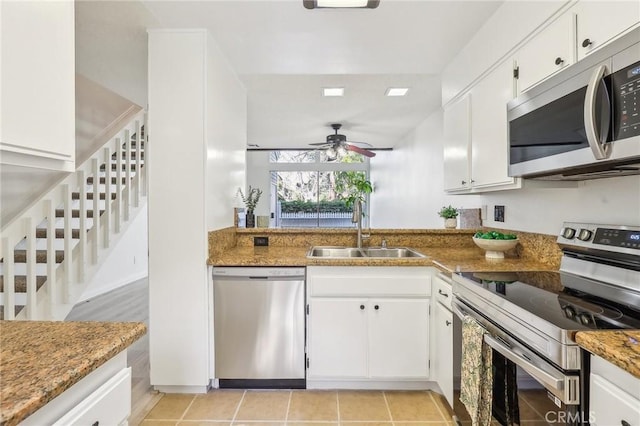 25447 Pine Creek Ln, Wilmington, CA 90744 - kitchen featuring appliances with stainless steel finishes, a sink, ceiling fan, white cabinetry, and light tile patterned floors