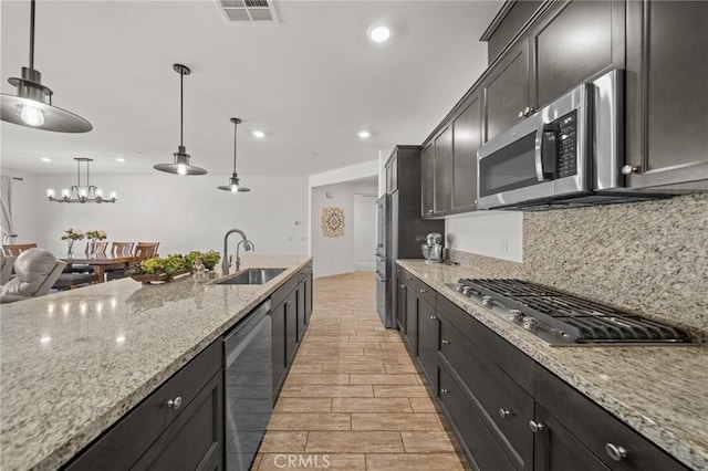 11066 Guffey Ranch Way, Corona, CA 92883 - kitchen with a sink, appliances with stainless steel finishes, light stone counters, decorative light fixtures, and tasteful backsplash