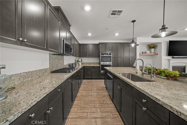 11066 Guffey Ranch Way, Corona, CA 92883 - kitchen with a sink, appliances with stainless steel finishes, light stone countertops, recessed lighting, and decorative light fixtures