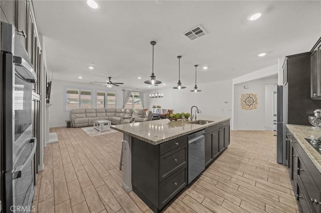 11066 Guffey Ranch Way, Corona, CA 92883 - kitchen featuring a sink, appliances with stainless steel finishes, light wood-type flooring, open floor plan, and a kitchen island with sink