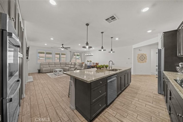 11066 Guffey Ranch Way, Corona, CA 92883 - kitchen with stainless steel appliances, light wood-type flooring, open floor plan, a center island with sink, and recessed lighting