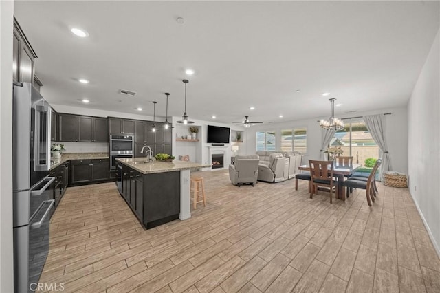 11066 Guffey Ranch Way, Corona, CA 92883 - kitchen featuring fridge, stainless steel double oven, light wood-style flooring, a ceiling fan, and recessed lighting