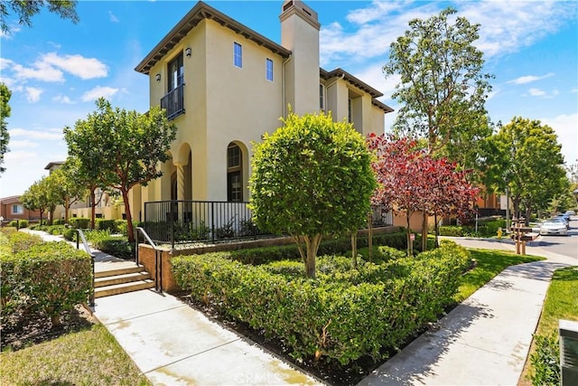 36 Chula Vis Unit 109, Irvine, CA 92602 - view of front facade featuring stucco siding and a chimney
