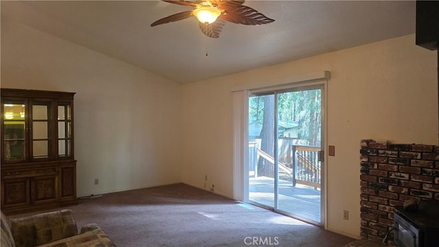 14093 Wingate Cir, Magalia, CA 95954 - unfurnished living room featuring carpet floors, ceiling fan, a wood stove, and vaulted ceiling