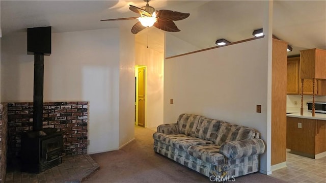 14093 Wingate Cir, Magalia, CA 95954 - living room with a ceiling fan, a wood stove, vaulted ceiling, baseboards, and light colored carpet
