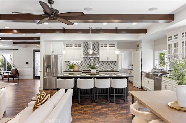 1202 Duke Ln, Walnut, CA 91789 - kitchen with appliances with stainless steel finishes, wall chimney range hood, a breakfast bar area, decorative backsplash, and a sink