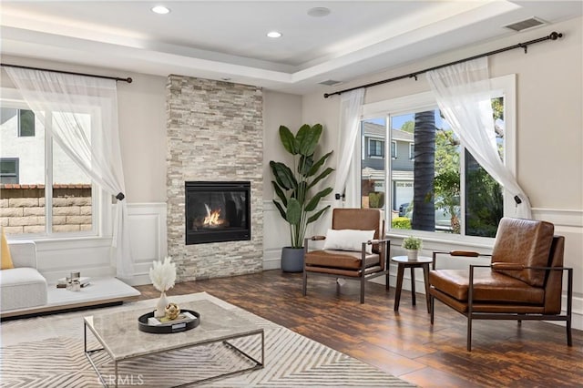 1202 Duke Ln, Walnut, CA 91789 - living area with a stone fireplace, wood finished floors, a raised ceiling, wainscoting, and recessed lighting