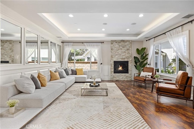 1202 Duke Ln, Walnut, CA 91789 - living area with a tray ceiling, hardwood / wood-style floors, a stone fireplace, and recessed lighting