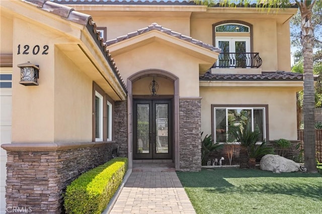1202 Duke Ln, Walnut, CA 91789 - property entrance featuring french doors, a balcony, stucco siding, stone siding, and a lawn