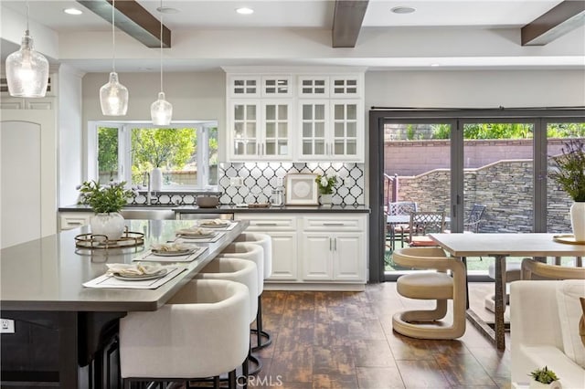 1202 Duke Ln, Walnut, CA 91789 - kitchen with dark countertops, beam ceiling, a sink, white cabinets, and a kitchen island