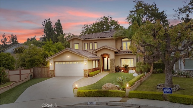 1202 Duke Ln, Walnut, CA 91789 - mediterranean / spanish-style home featuring an attached garage, stucco siding, stone siding, and driveway