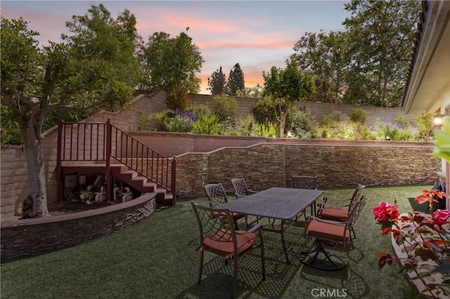 1202 Duke Ln, Walnut, CA 91789 - patio terrace at dusk featuring a fenced backyard, stairs, and outdoor dining area