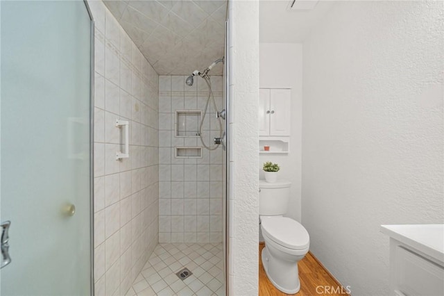 1424 E Vine Ave, West Covina, CA 91791 - bathroom featuring a shower stall, toilet, vanity, wood finished floors, and a textured wall