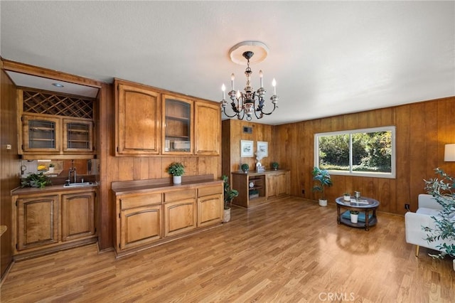 1424 E Vine Ave, West Covina, CA 91791 - dining space with a chandelier, wooden walls, and light wood-style floors