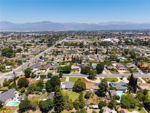 1424 E Vine Ave, West Covina, CA 91791 - aerial overview of property's location featuring a mountain backdrop, a pool, and nearby suburban area