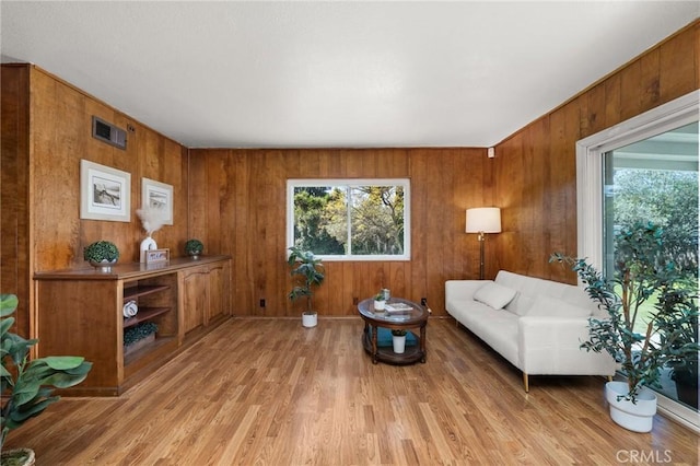 1424 E Vine Ave, West Covina, CA 91791 - living area featuring healthy amount of natural light, light wood-style flooring, and wooden walls