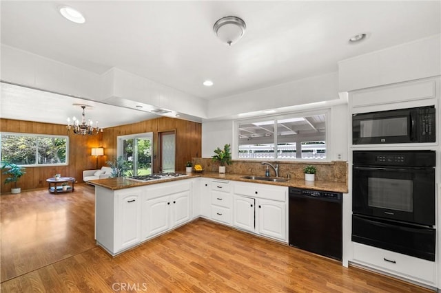 1424 E Vine Ave, West Covina, CA 91791 - kitchen featuring black appliances, a warming drawer, a sink, a chandelier, and white cabinets