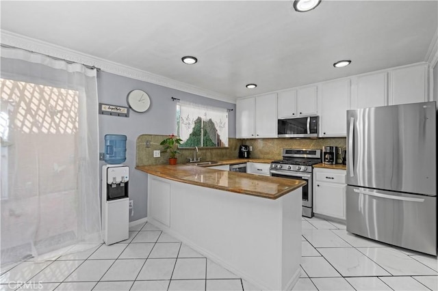 9158 Van Nuys Blvd Unit 8, Panorama City, CA 91402 - kitchen featuring stainless steel appliances, a sink, white cabinetry, a peninsula, and decorative backsplash