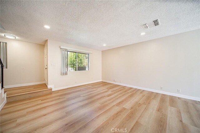 11408 Herb St Unit 7, South El Monte, CA 91733 - empty room featuring light wood-style floors, a textured ceiling, recessed lighting, baseboards, and stairs