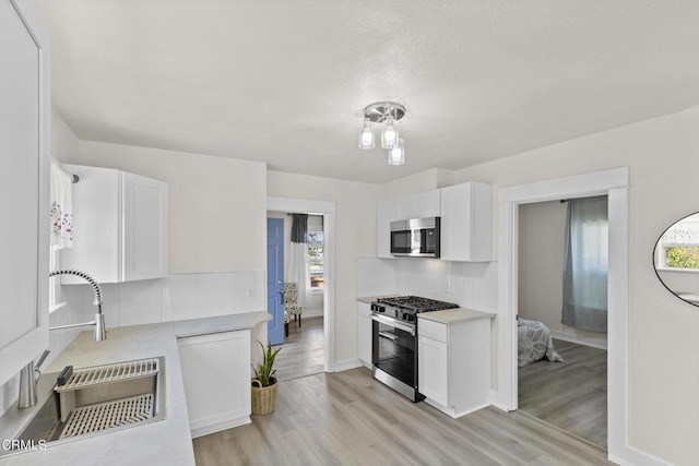 618 S C St, Oxnard, CA 93030 - kitchen with appliances with stainless steel finishes, a sink, healthy amount of natural light, and white cabinetry
