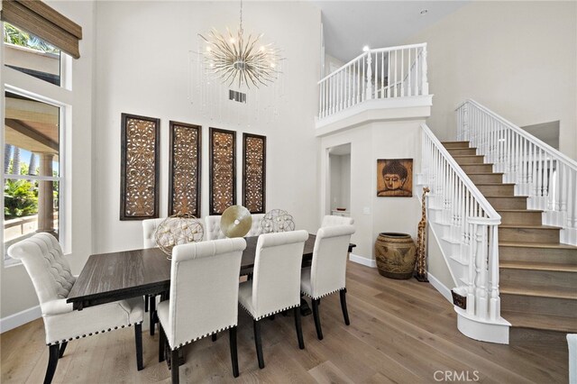 18976 Rockinghorse Ln, Huntington Beach, CA 92648 - dining room with healthy amount of natural light, wood finished floors, a chandelier, stairs, and a high ceiling