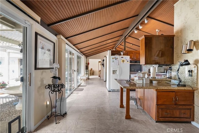 21166 E Rimpath Dr, Covina, CA 91724 - kitchen with white refrigerator with ice dispenser, stainless steel oven, baseboards, brown cabinets, and track lighting