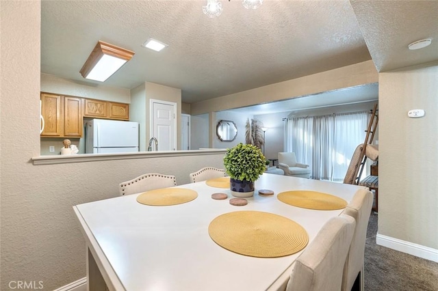 2881 Huntington Blvd Unit 137, Fresno, CA 93721 - dining space with a textured ceiling, baseboards, dark colored carpet, and a textured wall