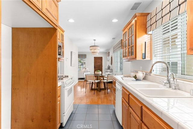 1518 Ocean Ave, Seal Beach, CA 90740 - kitchen with white appliances, a sink, tile countertops, glass insert cabinets, and a chandelier